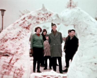 grupa osób patrzy na rzeźbę lodową znajdującą się na pierwszym planie